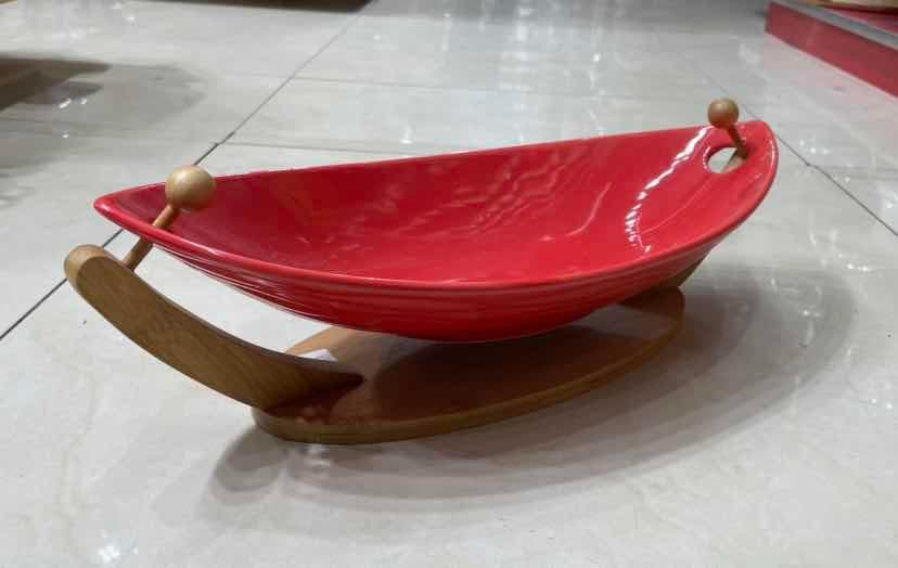 Red Ceramic Boat-Shaped Fruit Bowl on Curved Bamboo Cradle