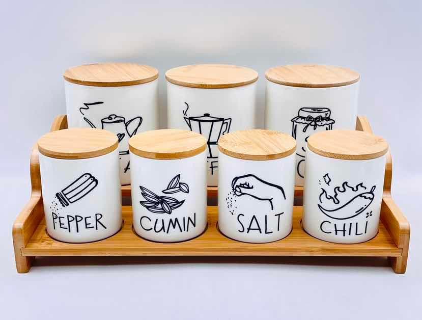 7-Piece Illustrated Ceramic Spice Jar Set with Bamboo Lids on Two-Tier Tray